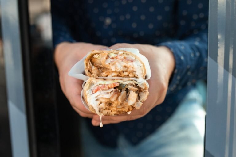 a person holding a shawarma