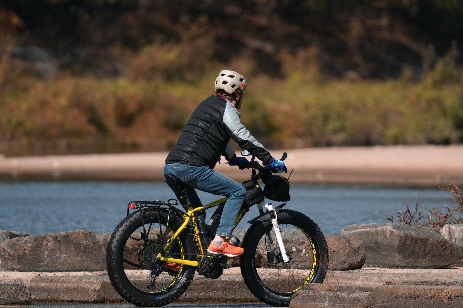 cyclist riding along the river on a fat bike