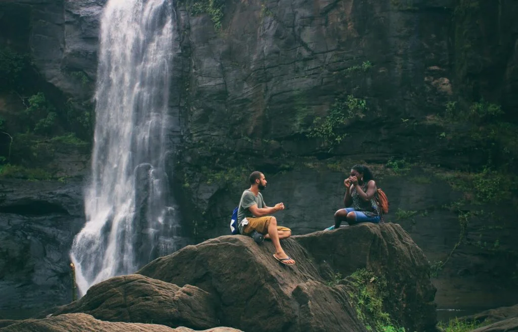 Viaggiare Sostenibile: 10 Consigli per Ridurre il Tuo Impatto Ambientale 2 man and woman near waterfall
